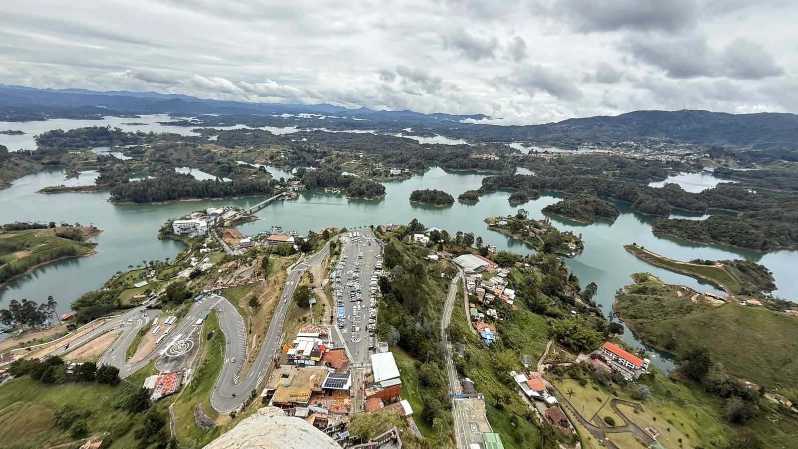 Aerial view of Guatape, Colombia, with the town's rooftops and the green lake islands stretching out below the viewpoint
