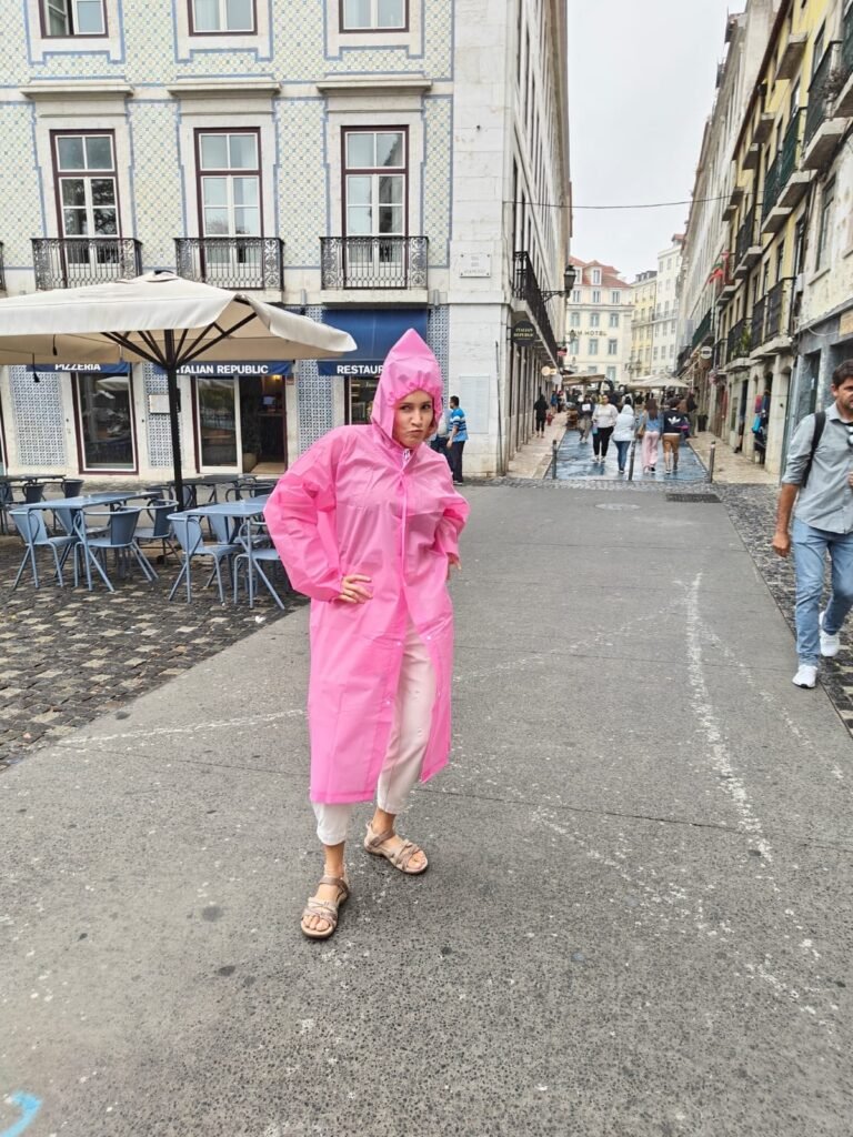 Bea in a pink raincoat on a pedestrian street in Portugal, September 2024